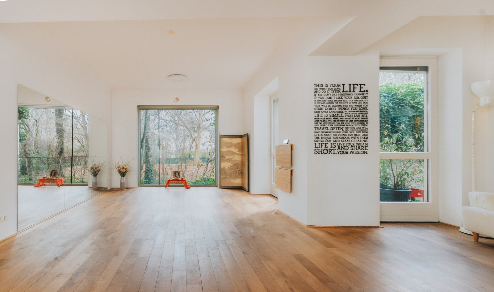 Der helle Yogaraum im Annapurna Space mit Holzboden und Blick in den Garten